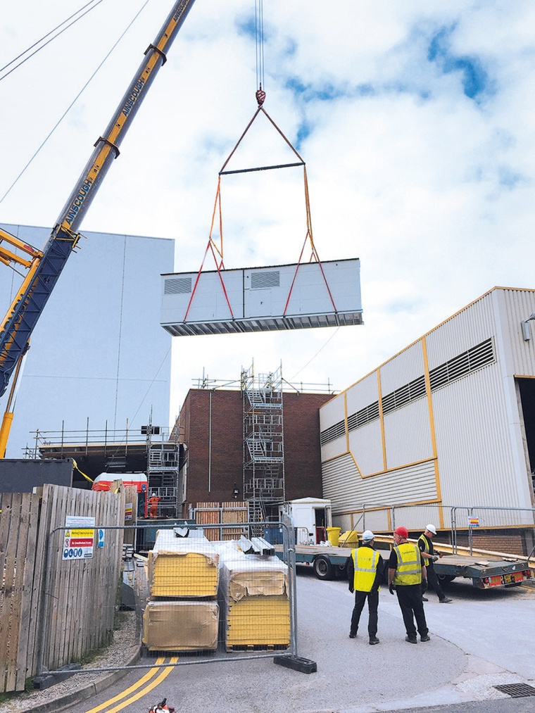 Nachdem der Container über mehrere Gebäude gehoben wurde, landete er sanft am...