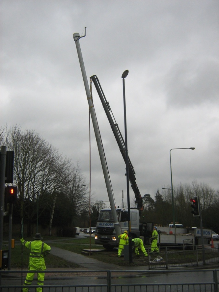 The column, nearly vertical, is manoeuvred into position.