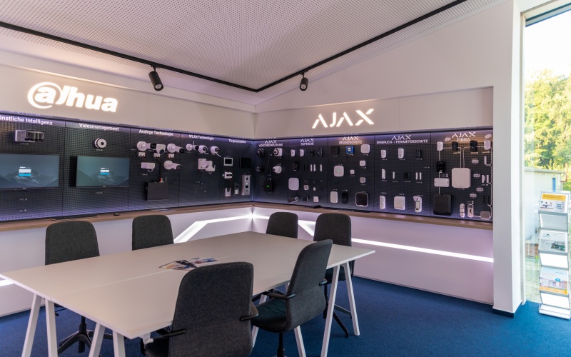 Showroom mit an den Wänden installierten Produkten von Dahua und Ajax