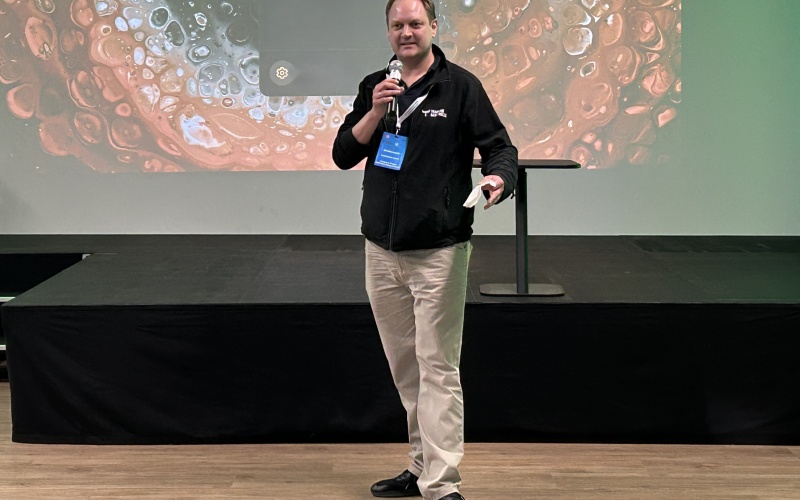 Mann mit Mikrofon vor Bühne