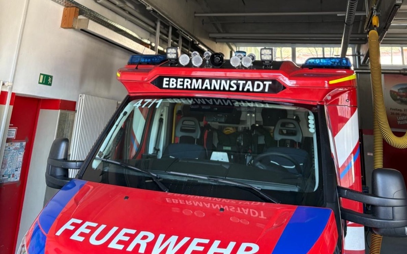Feuerwehrfahrzeug in einer Fahrzeughalle mit an der Decke installiertem Überwachungssensor