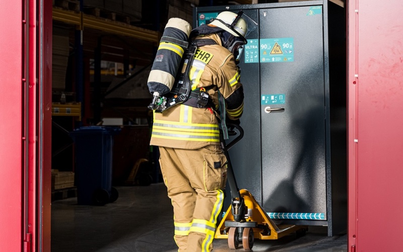 Feuerwehrmann vor Sicherheitsschrank