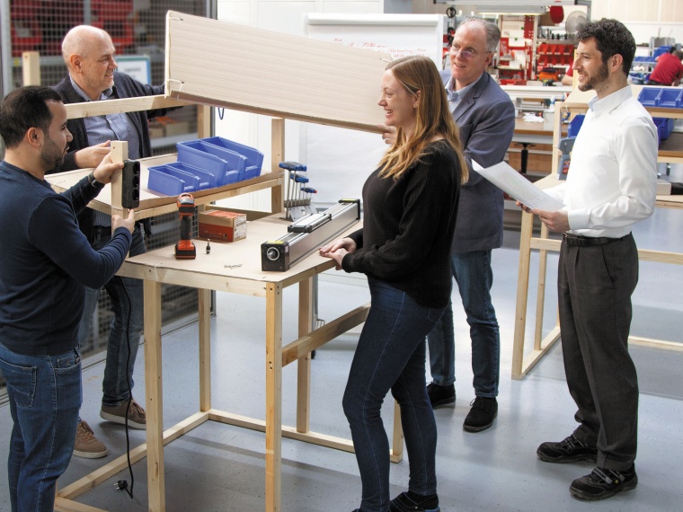 Während der Lean Solutions Workshops erarbeitet das Team ein Holz-Pappe-Modell...