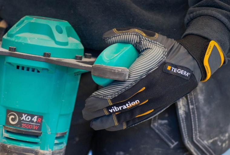 Person mit Tegera-Arbeitshandschuhen hält türkisfarbenes Elektrowerkzeug mit...