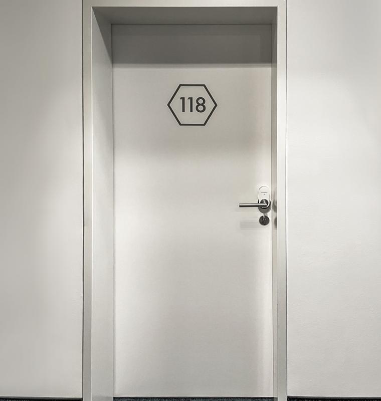 Weiße, verschlossene Hotelzimmertür mit der Zimmernummer 118