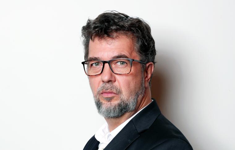 Profilbild von einem Mann mit schwarzem Blazer, grauem Vollbart, vollem Haar...