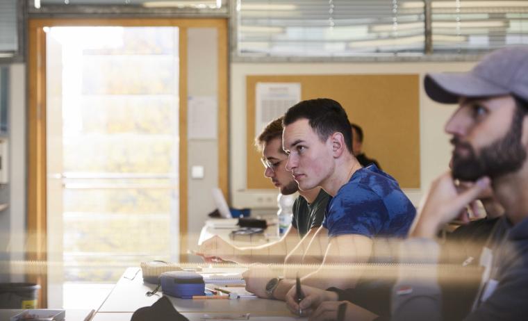 Drei männliche Studenten der THI in Profilansicht während einer Vorlesung