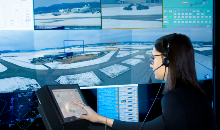 Frau vor der Remote Tower Solution mit großem Split-Bildschirm