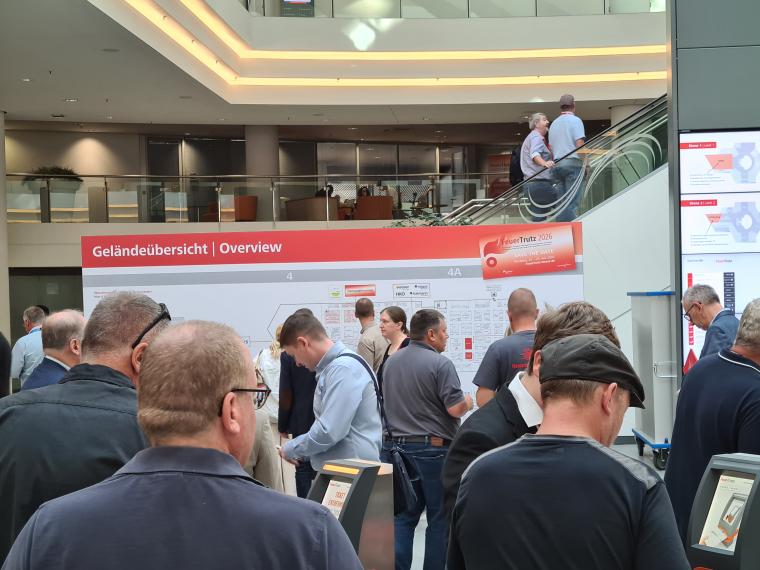 Besucher vor dem Geländeübersichtsstand in einem Messegebäude