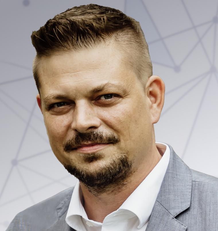 Portrait von Thomas Dallmeier mit weißem Hemd und grauem Sakko vor hellgrauem...