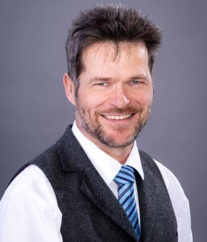 Johannes Strümpfel, Mann mit Drei-Tage-Bart in weißem Hemd, schwarzer Weste...