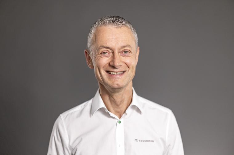Portrait von Frank Betsch in weißem Hemd vor dunkelgrauen Hintergrund