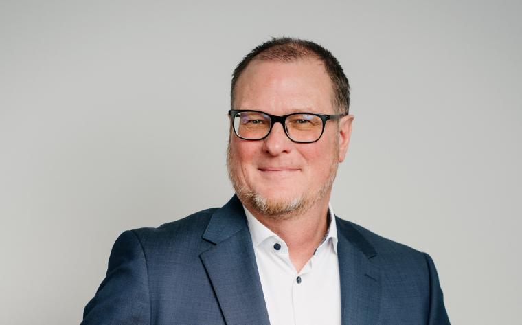 Bild von Marcus Alt mit dunkler Brille, hellem Hemd und dunklem Sakko vor...