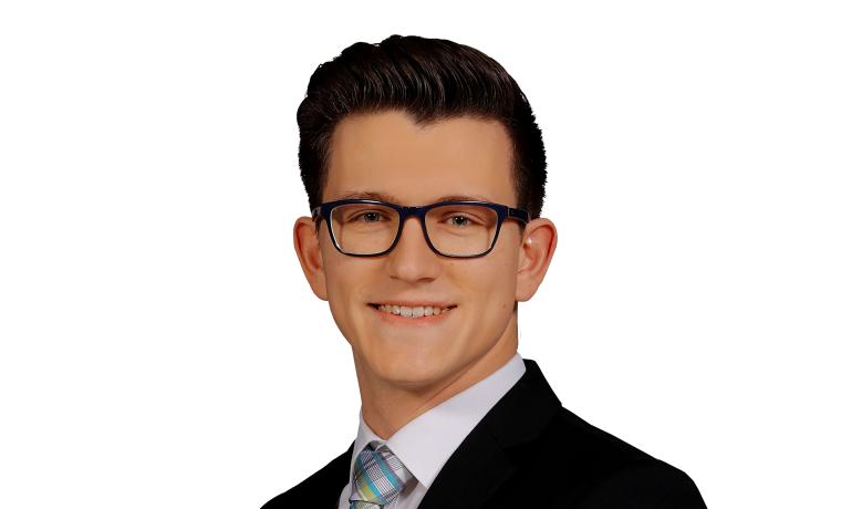 Portrait von Sören Jäckel mit Hemd, Sakko und Krawatte vor weißem Hintergrund