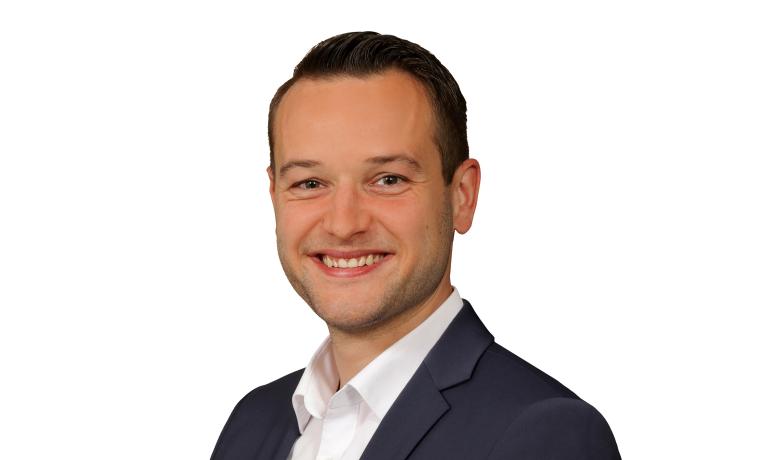 Portrait von Simon Mersch mit Hemd und Sakko vor weißem Hintergrund
