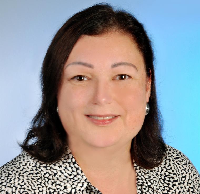 Portrait von Johanna Wünsch mit dunklem, offenen Haar und gepunkteter Bluse...