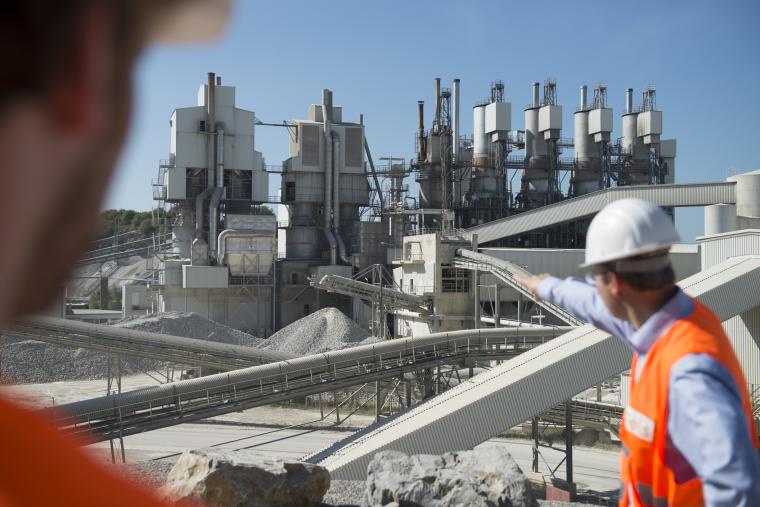 Kalksteinabbau-Werk, zwei Arbeiter mit Schutzkleidung im Vordergrund, ein...