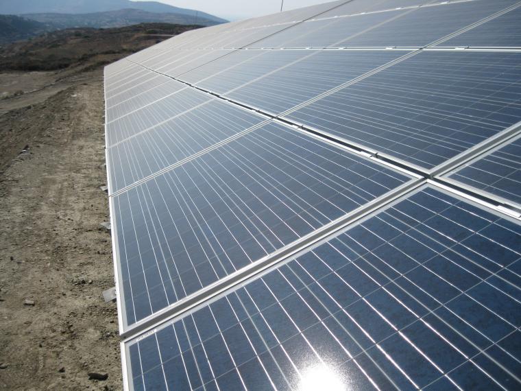 Große Freiflächen-Solaranlage mit mehreren Reihen geneigter Solarpanels, die...
