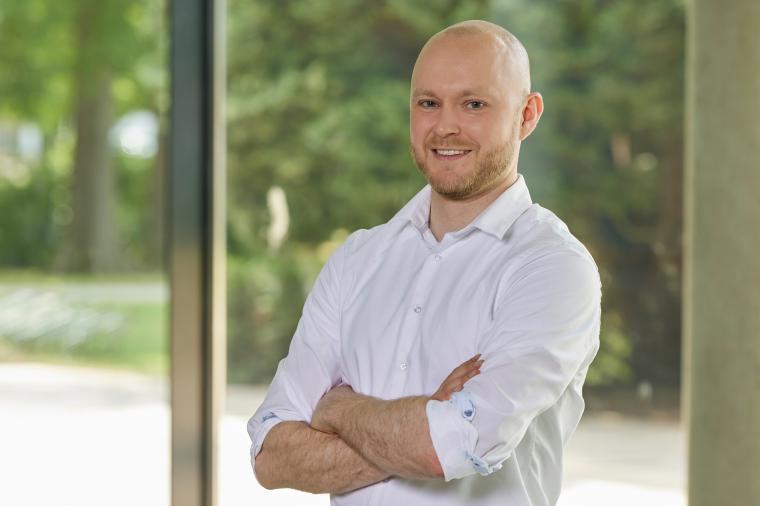 Lächelnder Mann mit weißem, hochgekrempeltem Hemd