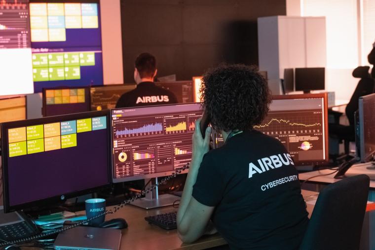 Mitarbeiter von Airbus Cybersecurity vor Überwachungsbildschirmen