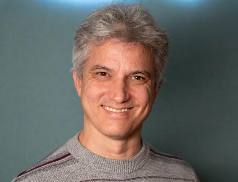 Grauhaariger mittelalter Mann mit gestreiftem Pullover