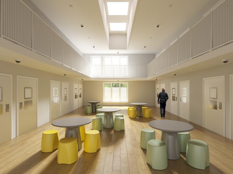 Innenhalle einer JVA mit mehreren Tischen und Hockern