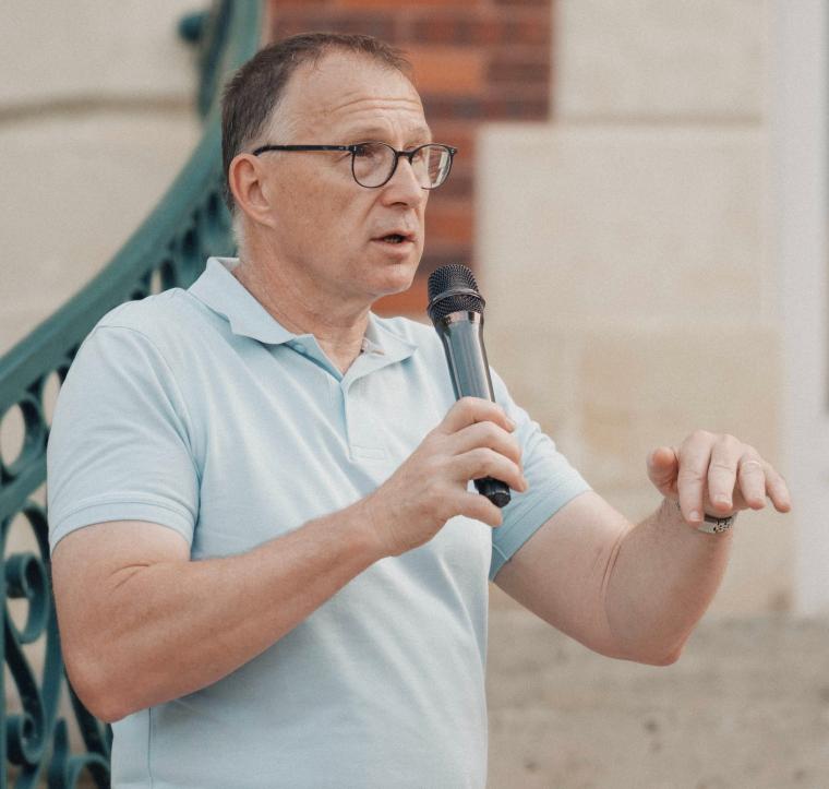 Bild von Marco Mille während eines Vortrages, er trägt Brille, ein helles...