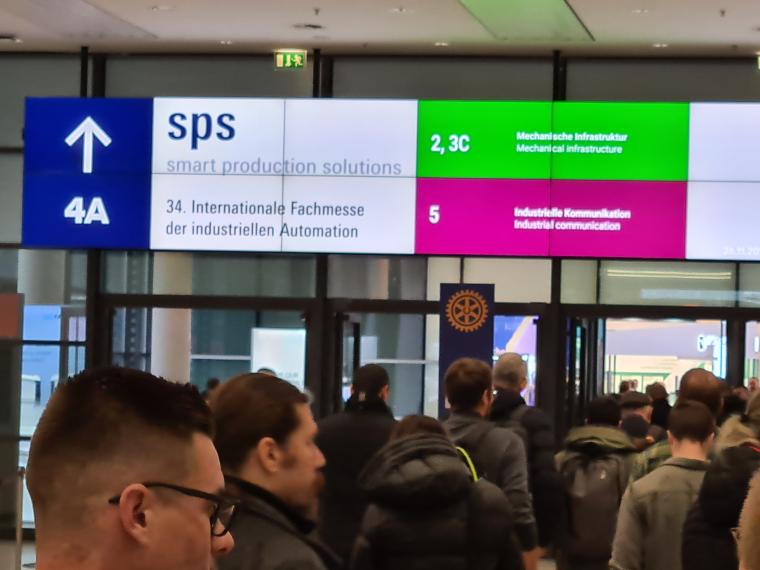 Besucher drängen durch einen Eingangstor in eine Halle