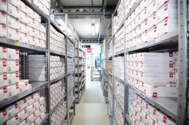 Regallager, gefüllt mit weißen Kartons mit roten Dom-Logos