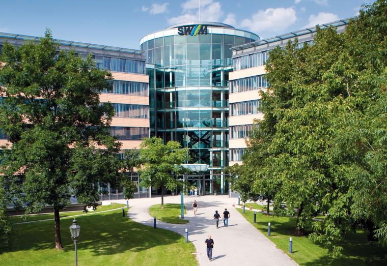 Bürogebäude mit gläsernem Rundbau im Zentrum mit Grünanlage