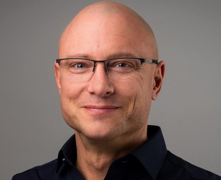 Barhäuptiger mittelalter lächelnder Mann mit Brille und schwarzem...