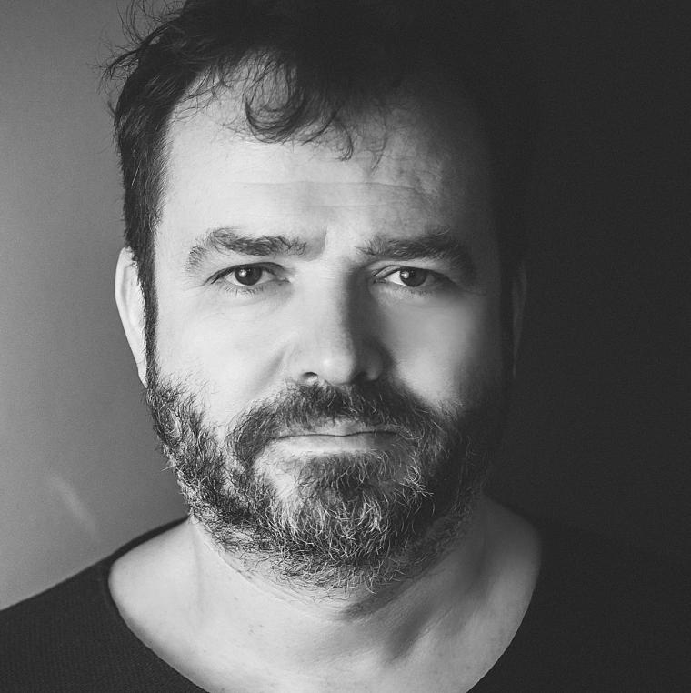 Schwarz-weiß-Bild eines bärtigen Mannes im mittleren Alter