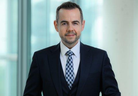 Jüngerer Mann mit Anzug und rautierter blauer Kravatte