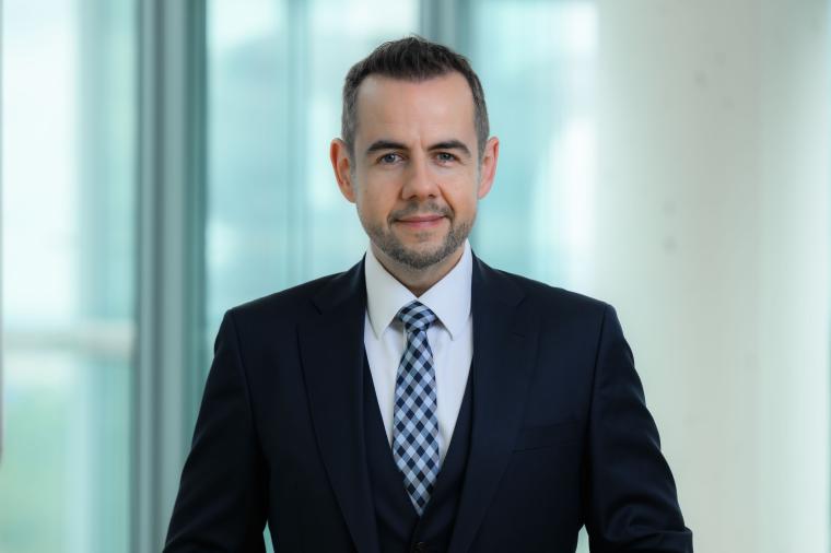 Jüngerer Mann mit Anzug und rautierter blauer Kravatte