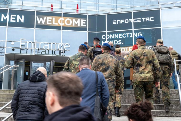 Menschen in Militäruniformen betreten die Messehalle der Enforce Tac in...