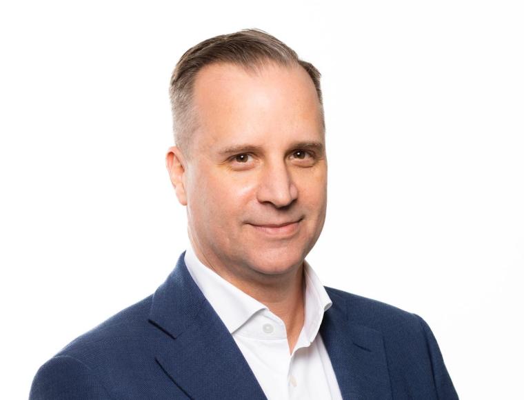 Mann mit blauem Sakko und weißem Hemd