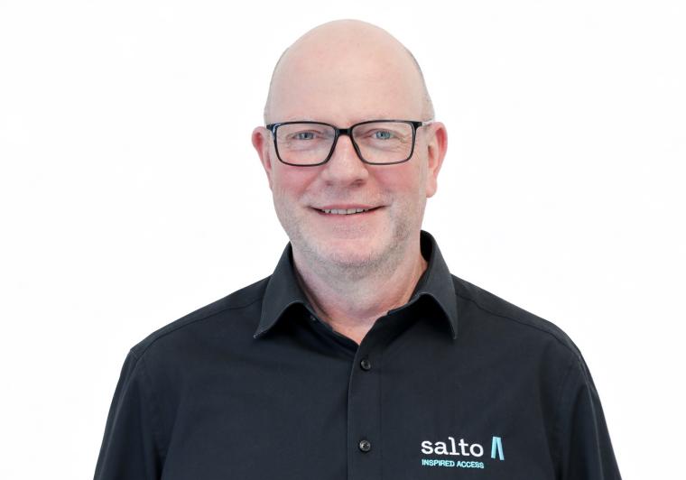 Mann mit schwarzer Brille und schwarzem Hemd mit Aufschrift „Salto“