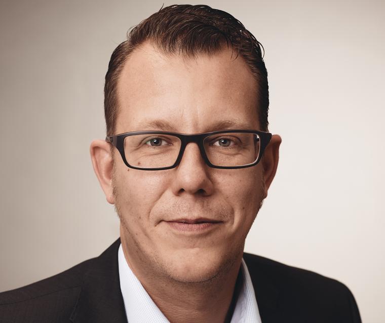 Porträtaufnahme einer Person im dunklen Sakko und  weißem Hemd
