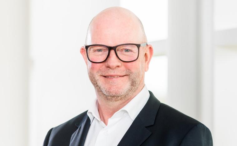 Mittelalter Mann mit Brille, weißem Hemd und dunkler Anzugjacke