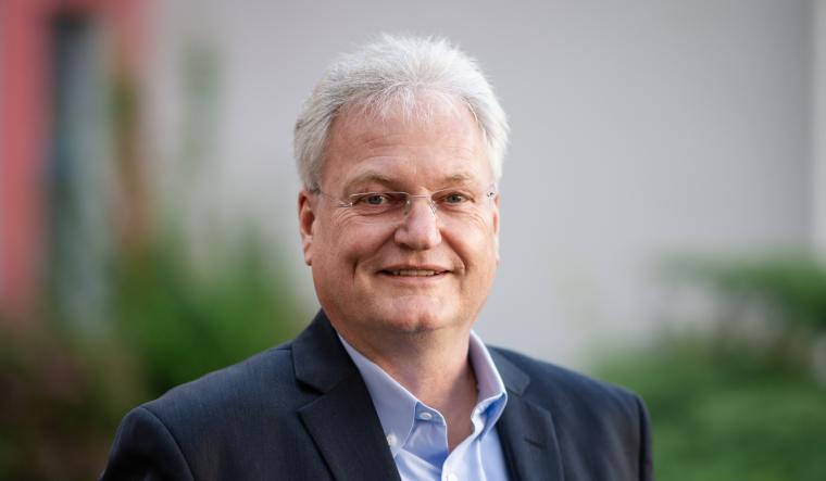 Älterer Mann mit blauem Anzug und grauen Haaren