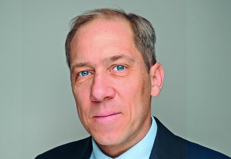 Portrait einer männlichen Person mittleren Alters mit hellem Hemd, dunkler...