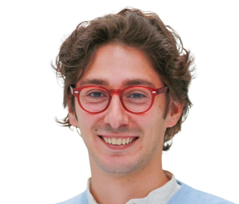Junger Mann mit Locken und roter Brille