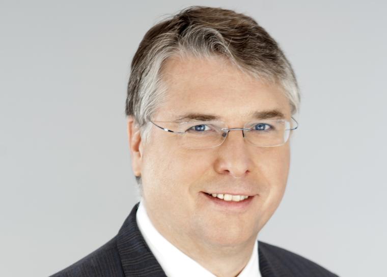 Middle aged man with glasses, suit and striped tie