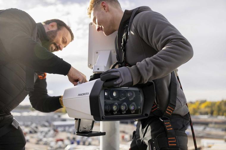 Two technicians install a Panomera multi-sensor security camera on a pole...