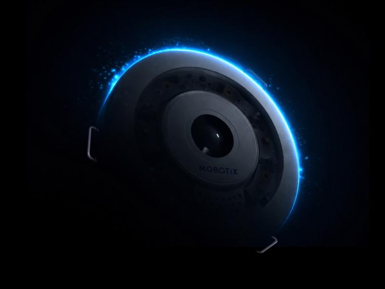 Close-up of a Mobotix security camera with a circular lens and a glowing blue...
