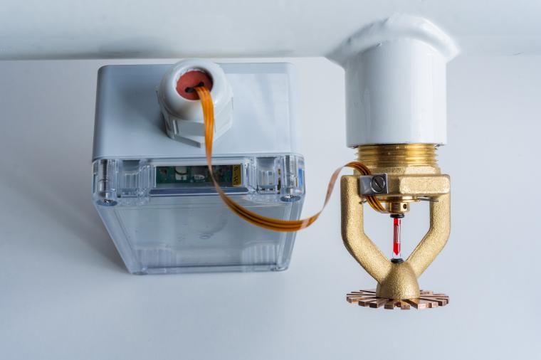 Deckenmontierter Sprinkler mit angeschlossenem transparentem Steuerungsmodul;...