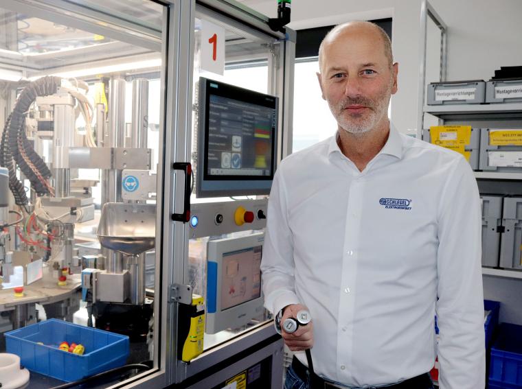 Person in einer industriellen Fertigungsanlage steht neben einer...