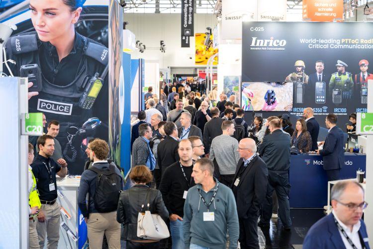 Messehalle voller Besucher und Messeständen