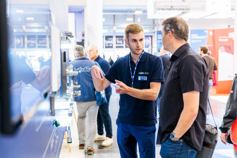 Busy exhibition hall with security technology exhibitors and visitors