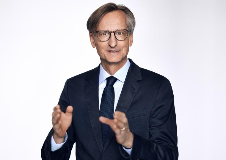 Person mit dunklem Anzug und Brille